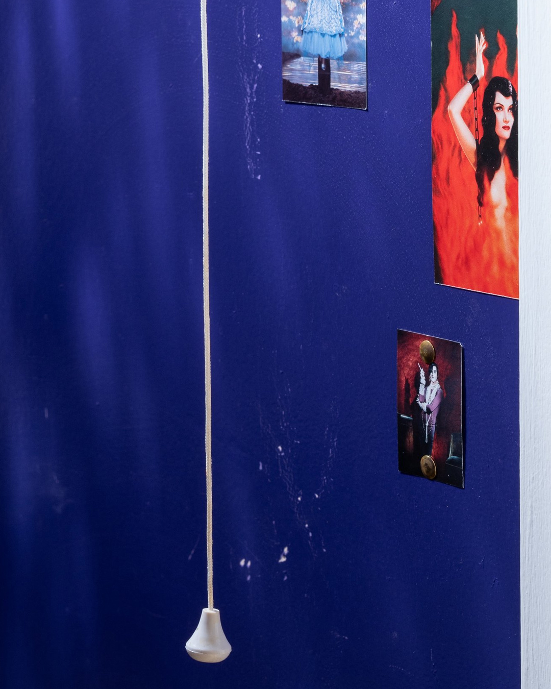 Changing Rooms event image: a blue wall with a hanging light pull and pinned photographs.